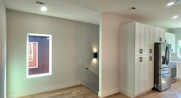 a view of kitchen with refrigerator and window
