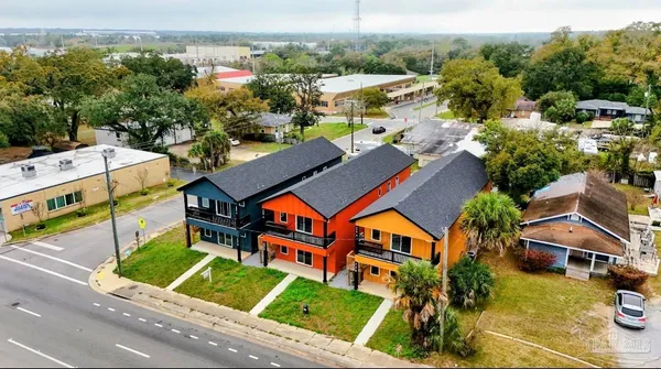 an aerial view of multiple houses with a big yard