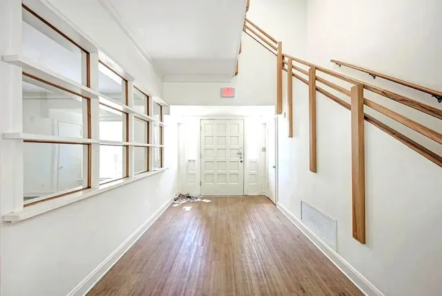 a view of hallway with wooden floor and stairs