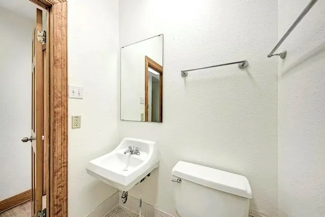 a bathroom with a toilet a sink and a mirror