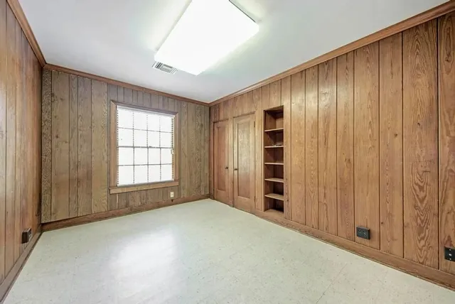 an empty room with windows closet and natural light
