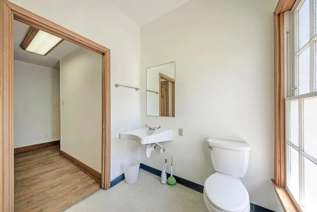 a bathroom with a toilet sink and a mirror