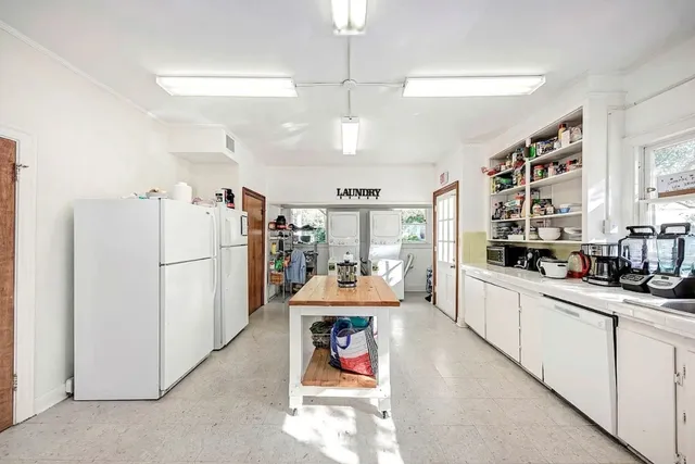 a kitchen with stainless steel appliances kitchen island granite countertop a refrigerator and microwave