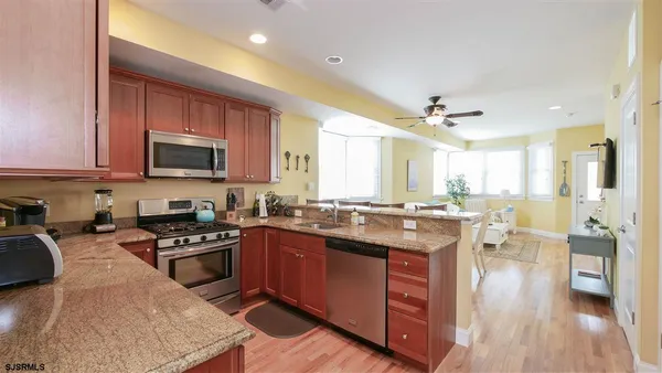 a kitchen with lots of counter top space a sink appliances and cabinets