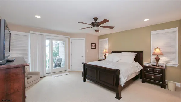 a spacious bedroom with a bed and a chandelier