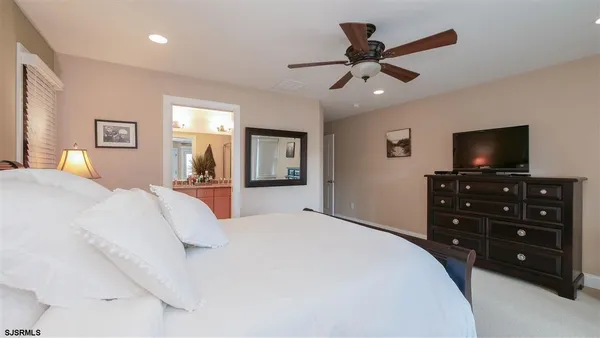 a bedroom with a bed a chandelier and a flat screen tv