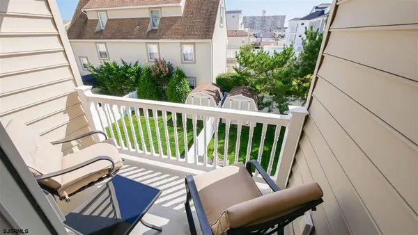 a view of a chair and tables in the balcony