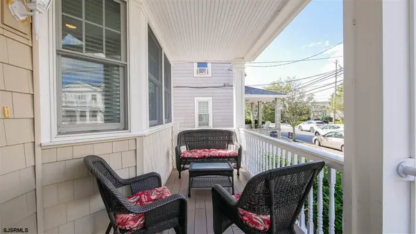 a balcony view with a couch and chairs
