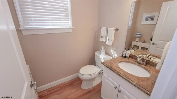 a bathroom with a granite countertop toilet sink and mirror