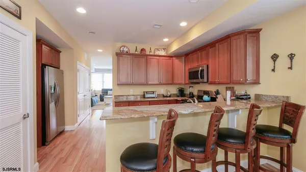 a kitchen with a dining table chairs and a refrigerator
