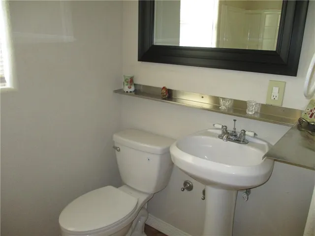 a bathroom with a sink a toilet and mirror