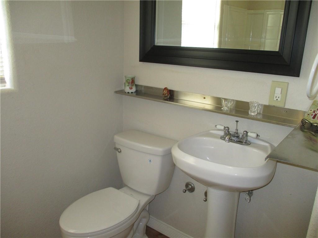 4110 Callicoatte Road Corpus Christi, TX 78410 - Photo 11 of 16 a bathroom with a sink a toilet and mirror