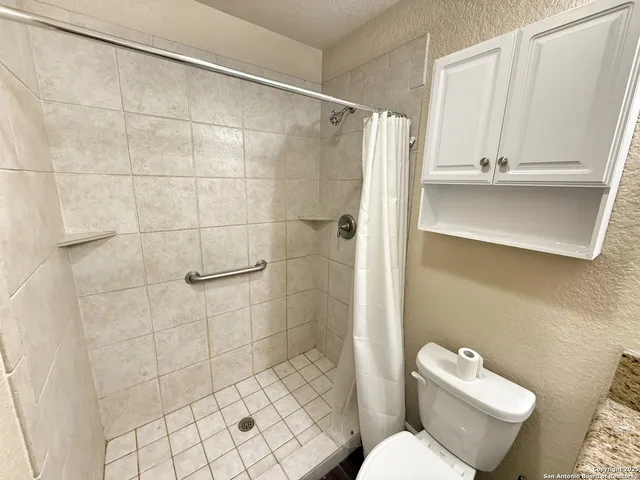 a white toilet sitting next to a bathroom sink and a shower