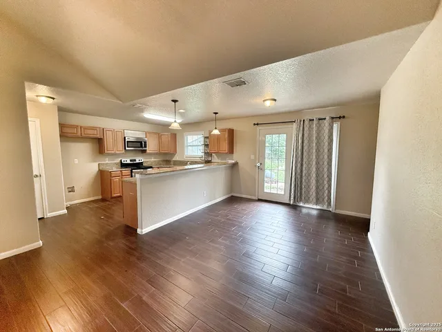 a view of kitchen with wooden floor and electronic appliances