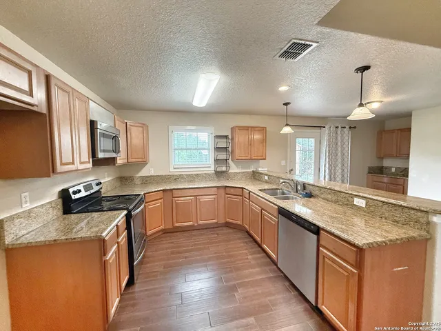 a large kitchen with stainless steel appliances granite countertop a large counter top and a stove