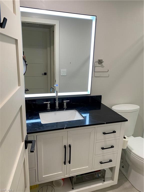 5717 Lago Villaggio Way Naples, FL 34104 - Photo 3 of 11 a bathroom with a sink and a mirror