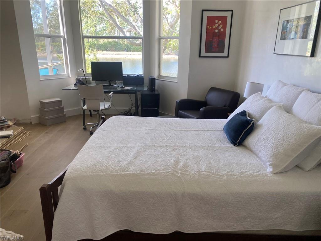 5717 Lago Villaggio Way Naples, FL 34104 - Photo 6 of 11 a bedroom with a bed a table window and a desk