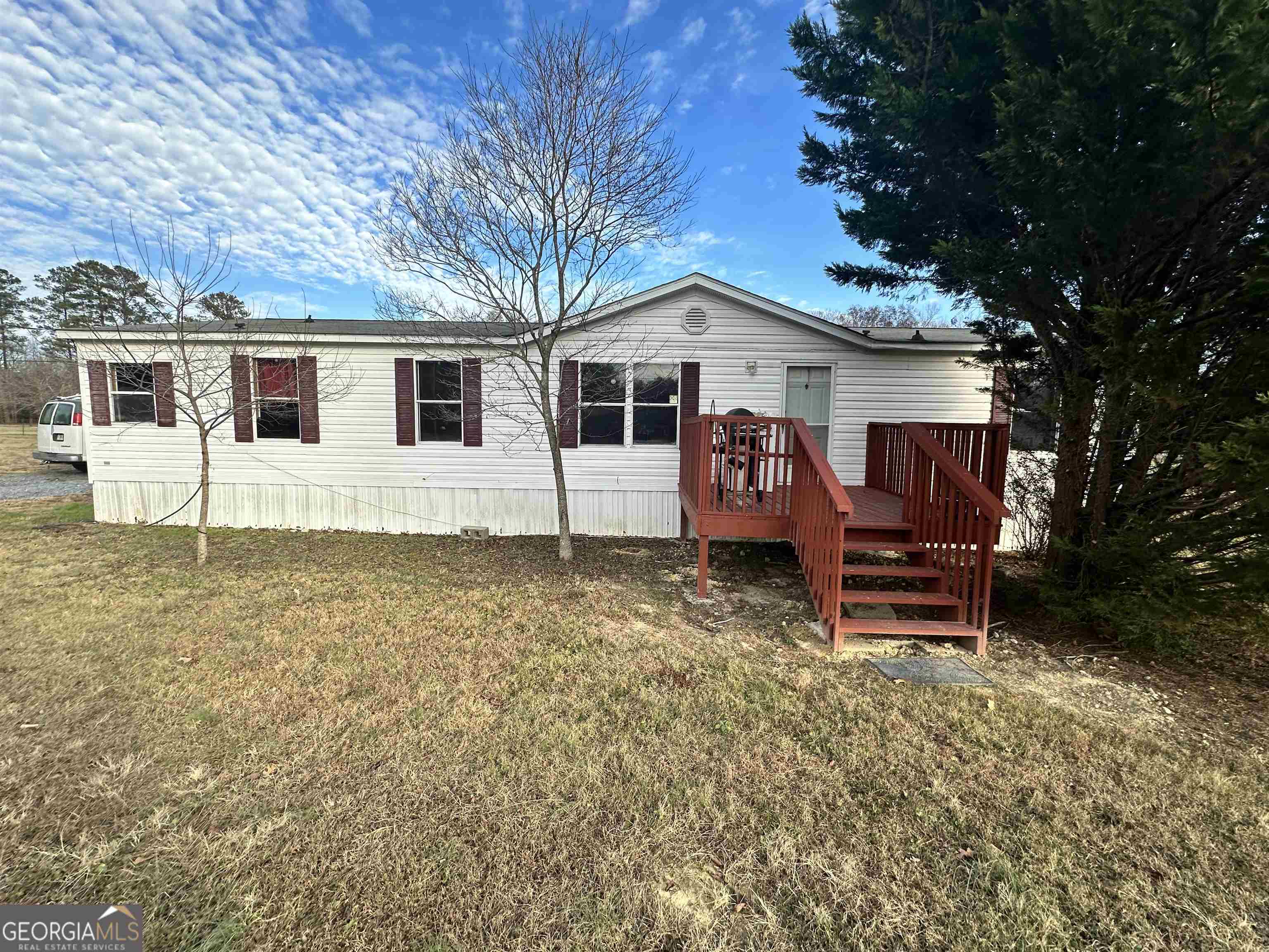 a view of a house with a yard chairs and a tree