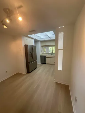 an empty room with windows and cabinet