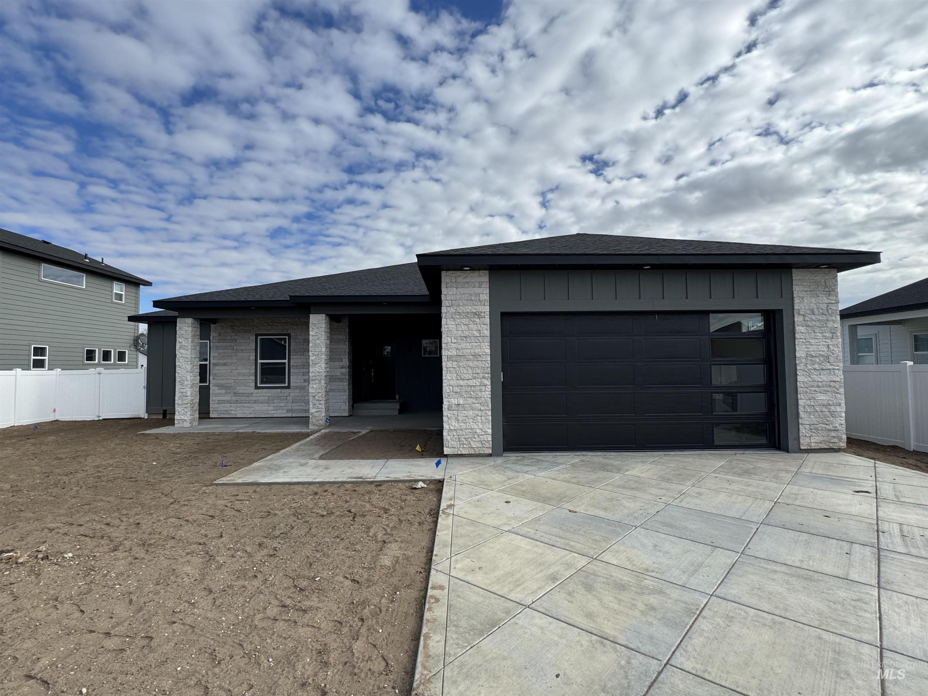 View of front of home featuring an attached garage, roof with shingles, concrete driveway, and covered porch