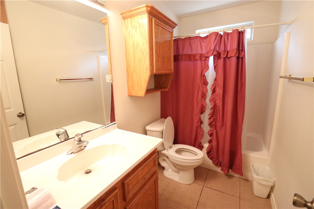 901 Strom Road Corpus Christi, TX 78418 - Photo 13 of 19 a bathroom with a sink a toilet and shower curtain