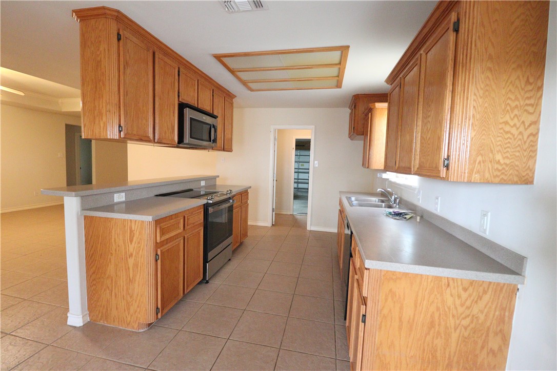 901 Strom Road Corpus Christi, TX 78418 - Photo 5 of 19 a kitchen with stainless steel appliances granite countertop a sink and a stove