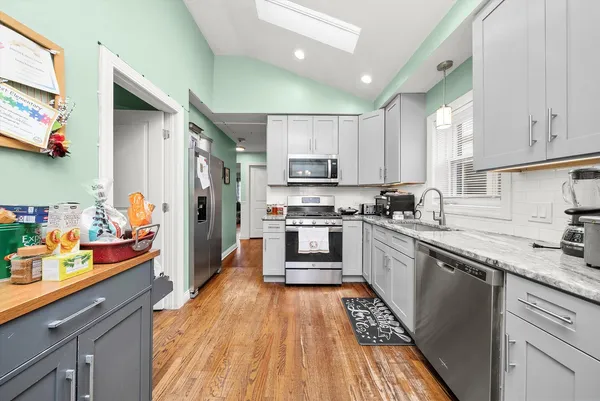 a kitchen with stainless steel appliances kitchen island granite countertop a refrigerator and a stove top oven
