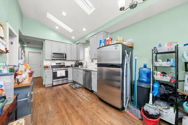 a kitchen with stainless steel appliances a refrigerator sink and wooden floor