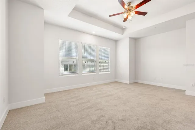 an empty room with a window and a fan