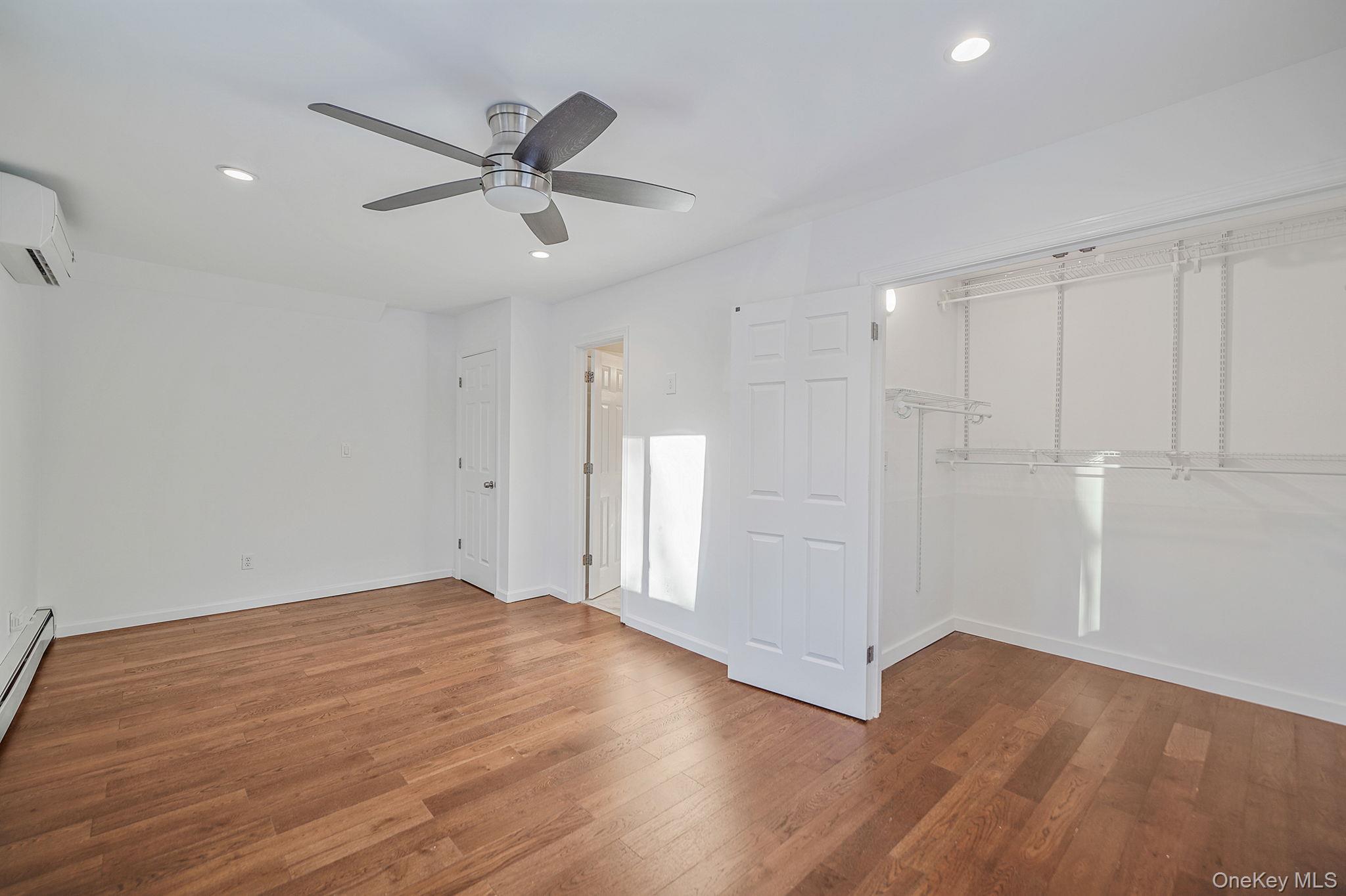 38 Hawthorne Road Rocky Point, NY 11778 - Photo 18 of 27 a view of an empty room with wooden floor and a ceiling fan