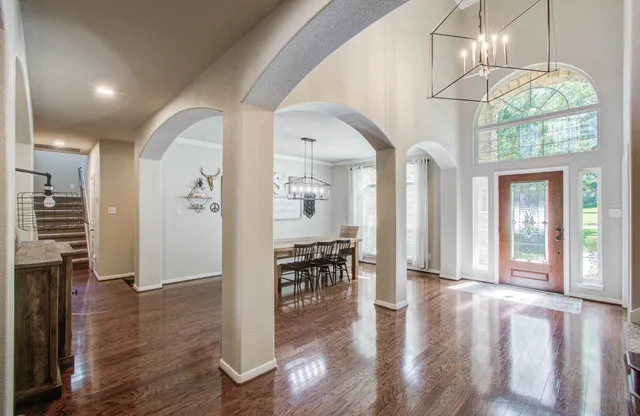 an entryway and livingroom with furniture wooden floor chandelier