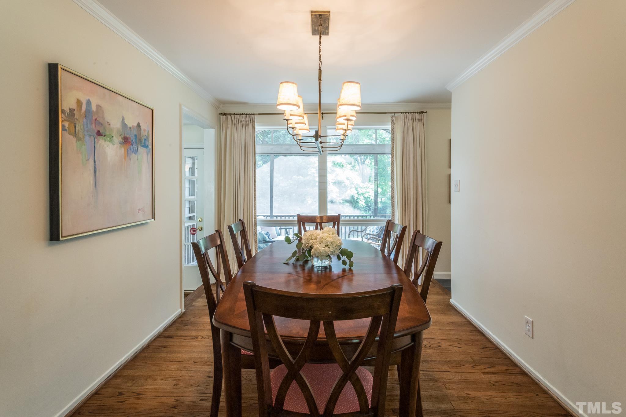 3431 Churchill Road Raleigh, NC 27607 - Photo 22 of 47 a dining room with furniture a chandelier and wooden floor