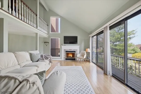 a living room with furniture a fireplace and a flat tv screen next to a large window