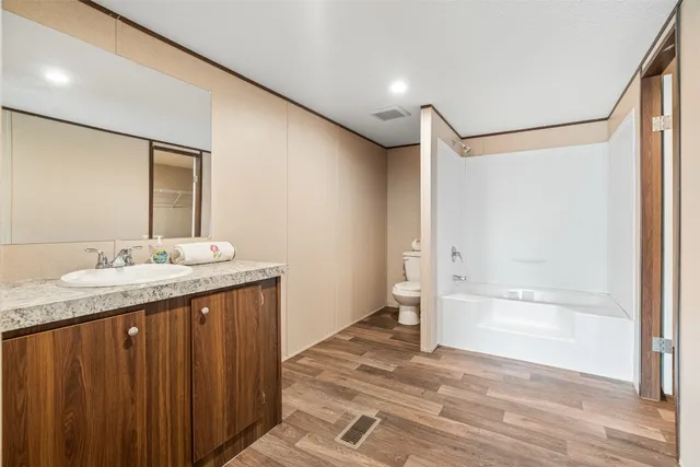 a view of an empty room with a kitchen and a window