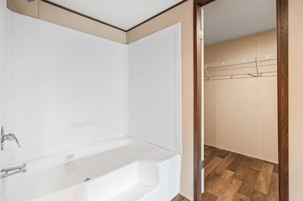 a view of an empty room with a kitchen and a window