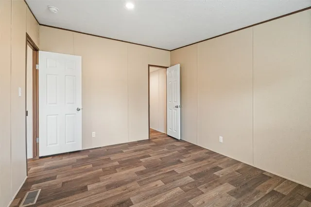 an empty room with wooden floor and window