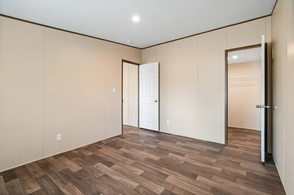 an empty room with wooden floor and window