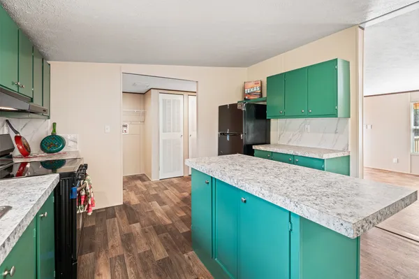 a kitchen with sink a refrigerator and a stove top oven