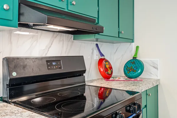 a bathroom with a granite countertop sink and washing machine