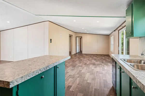 a view of an empty room with wooden floor and door