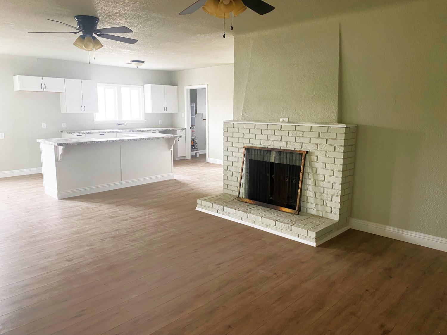931 F Street Reedley, CA 93654 - Photo 2 of 11 a view of an empty room with a fireplace and window