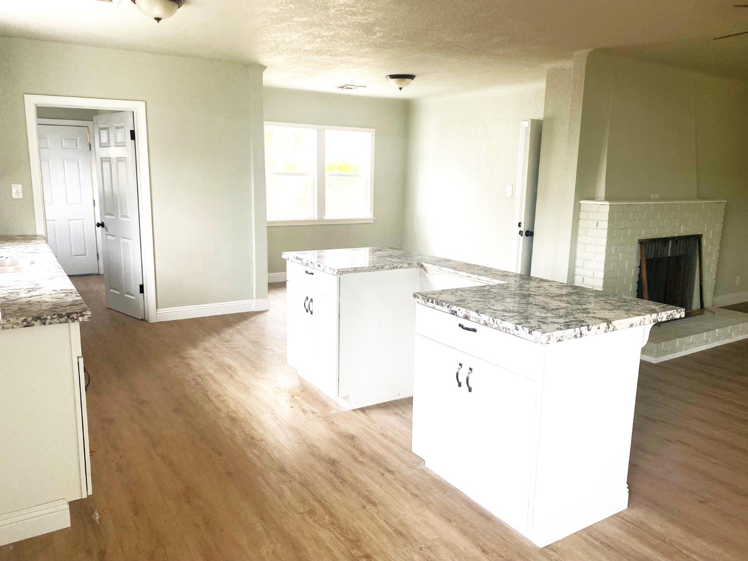 931 F Street Reedley, CA 93654 - Photo 3 of 11 a kitchen with a sink stove and wooden floor