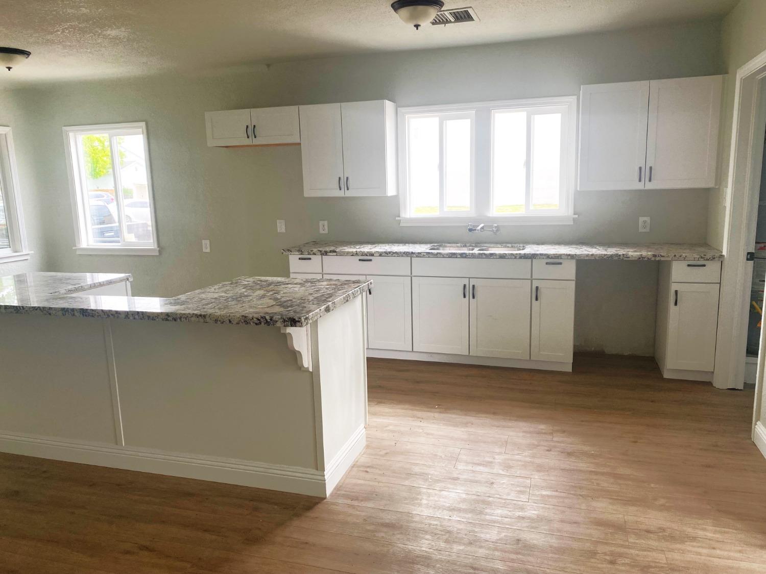 931 F Street Reedley, CA 93654 - Photo 4 of 11 a kitchen with granite countertop a sink window and cabinets