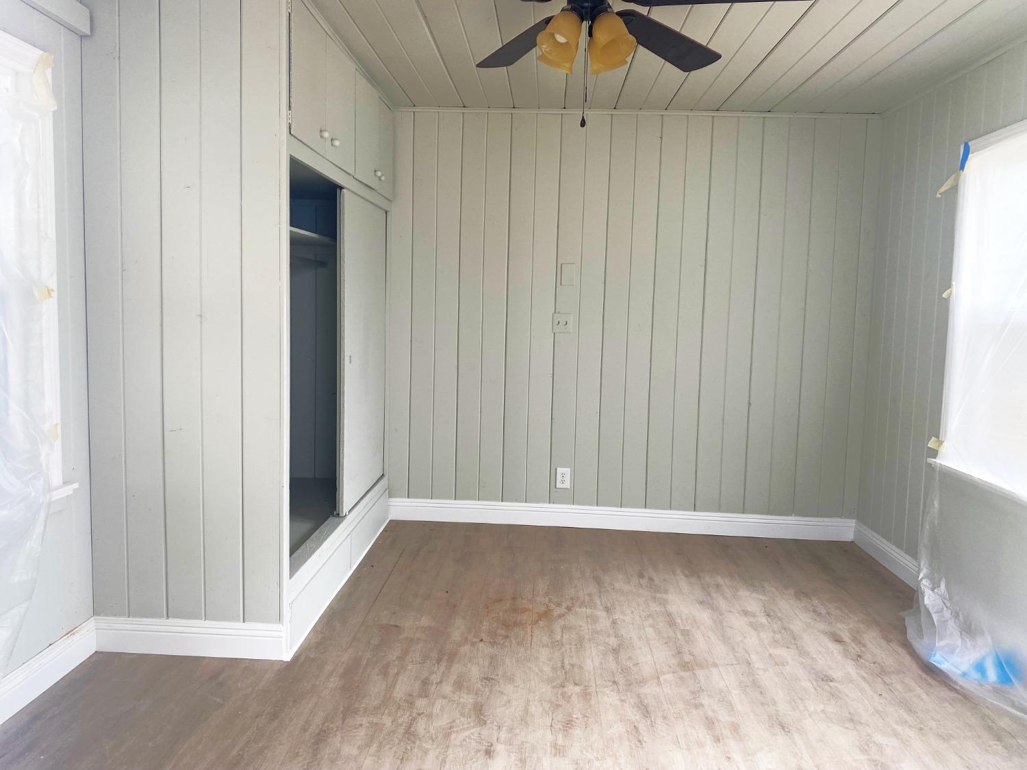 931 F Street Reedley, CA 93654 - Photo 10 of 11 an empty room with wooden floor fan and windows