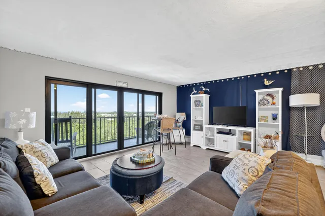 a living room with furniture a large window and a flat screen tv