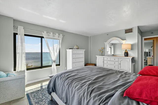 a bedroom with a large bed and a large window