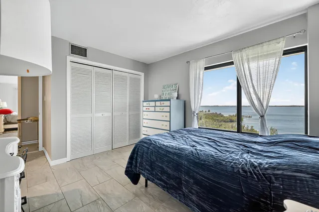 a bedroom with a large bed and a large window