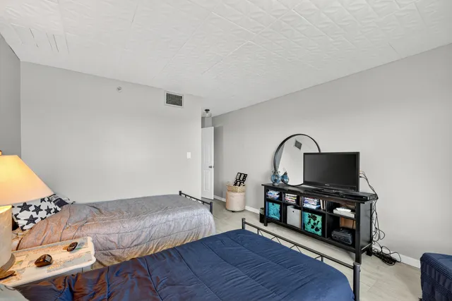a bedroom with a bed window and a flat screen tv