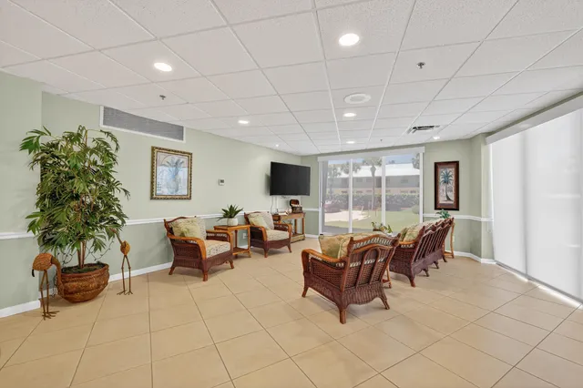 a living room with furniture a flat screen tv and a potted plant