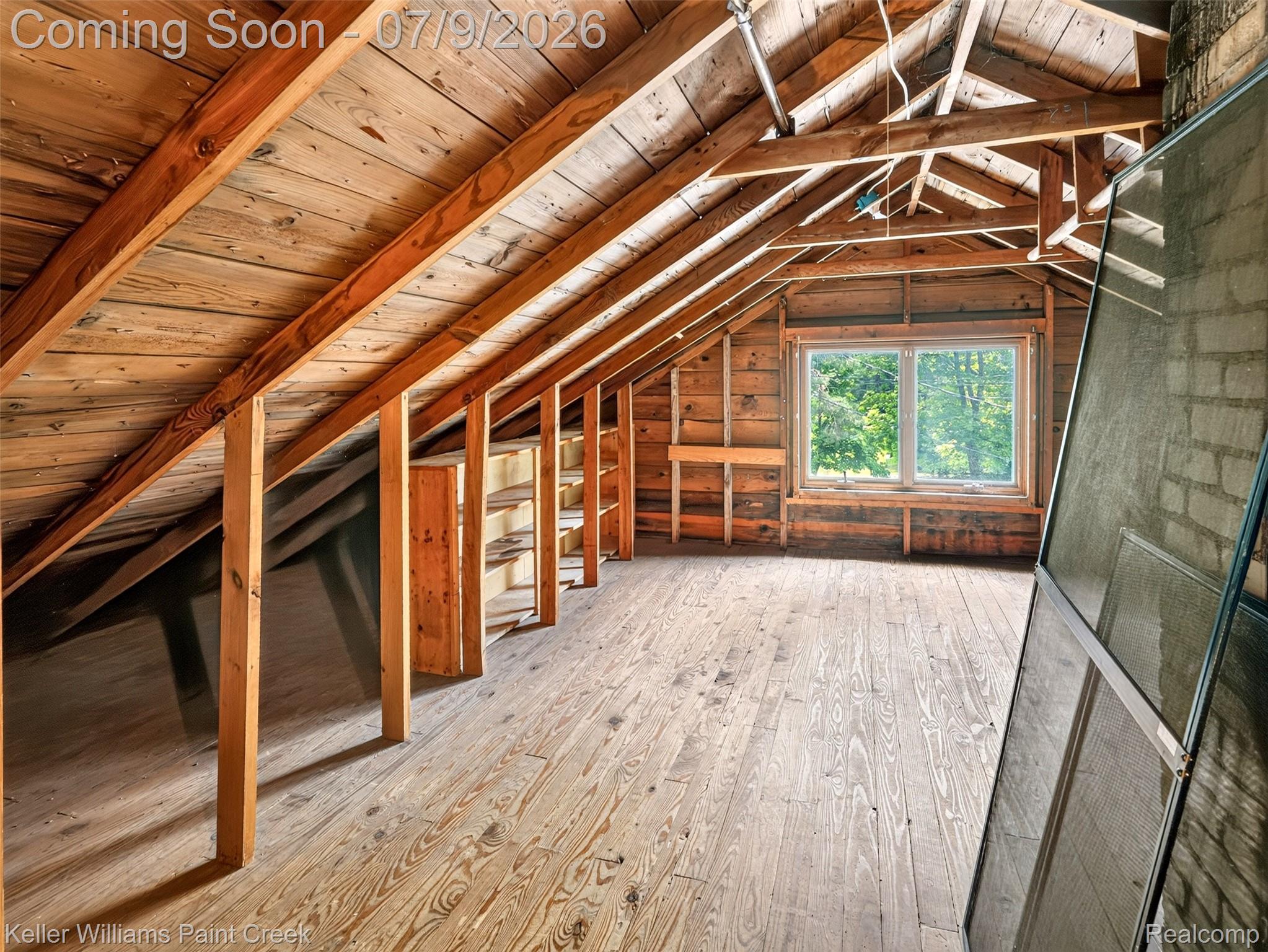 204 Russell Road Kawkawlin, MI 48631 - Photo 41 of 82 Spacious attic featuring exposed wood beams, wood-finish flooring, and natural light from a double window